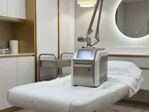 CO2 laser medisch apparaat op een behandelbed in een moderne esthetische kliniek met witte en stalen oppervlakken.